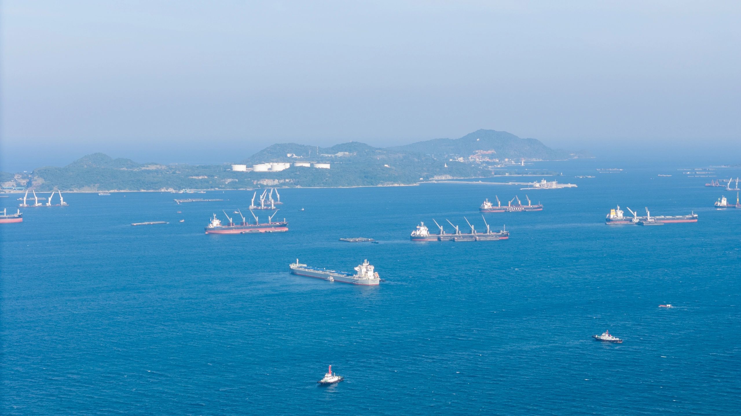 Barcos de carga fondeados cerca de un puerto industrial
